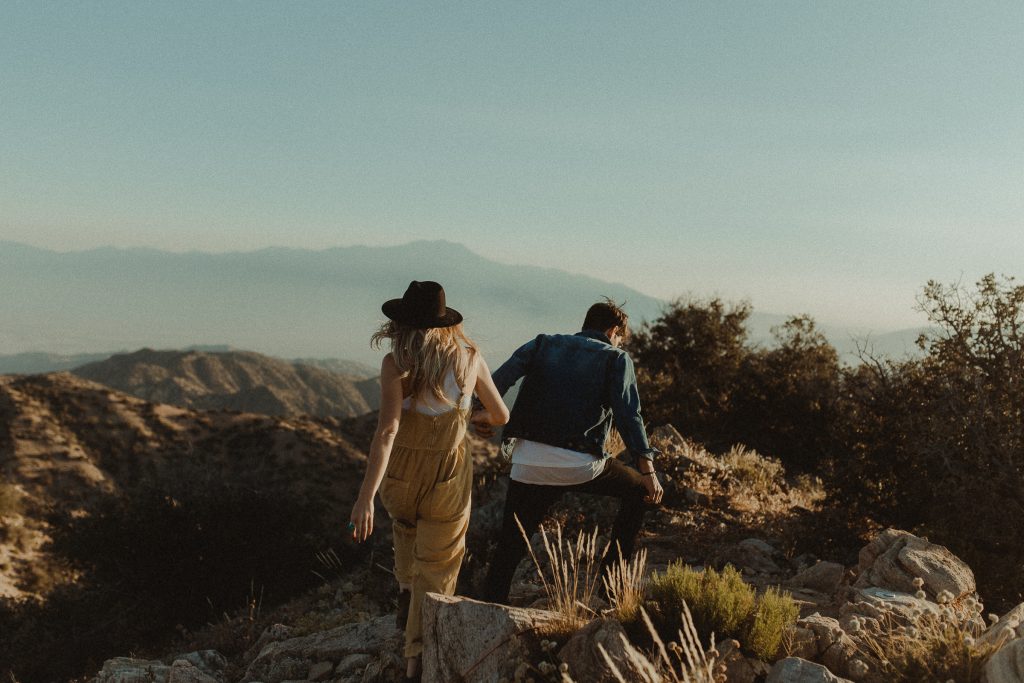 Engagement couple holding hands as they walk through the Joshua Tree National Park